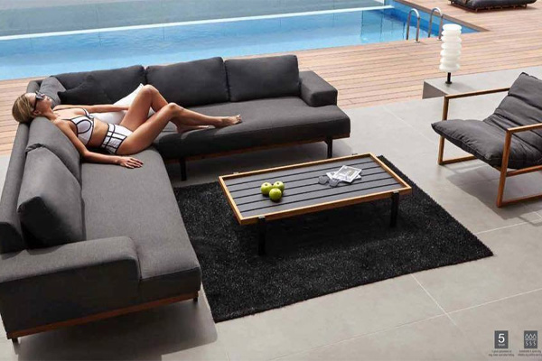 Woman sunbathing on an outdoor corner sofa in NZ.