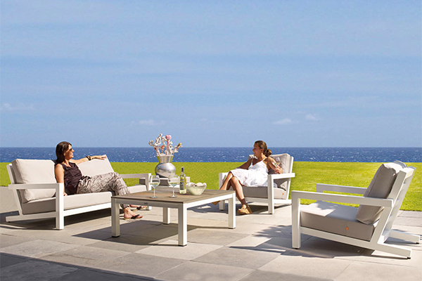Women sit outside relaxing on outdoor furniture in NZ.
