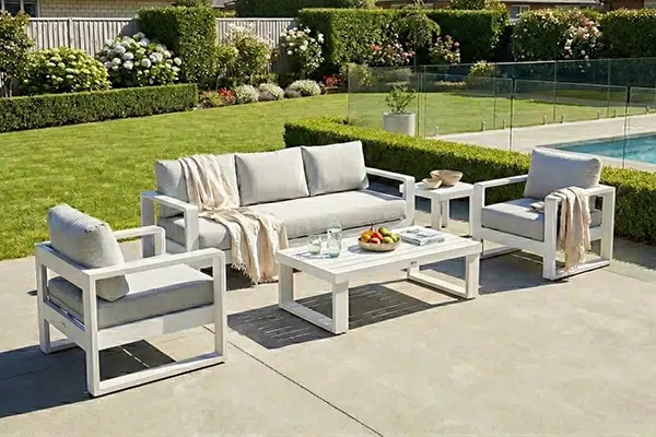 white powder coated aluminium outdoor lounge set with sofa and arm chairs beside a pool